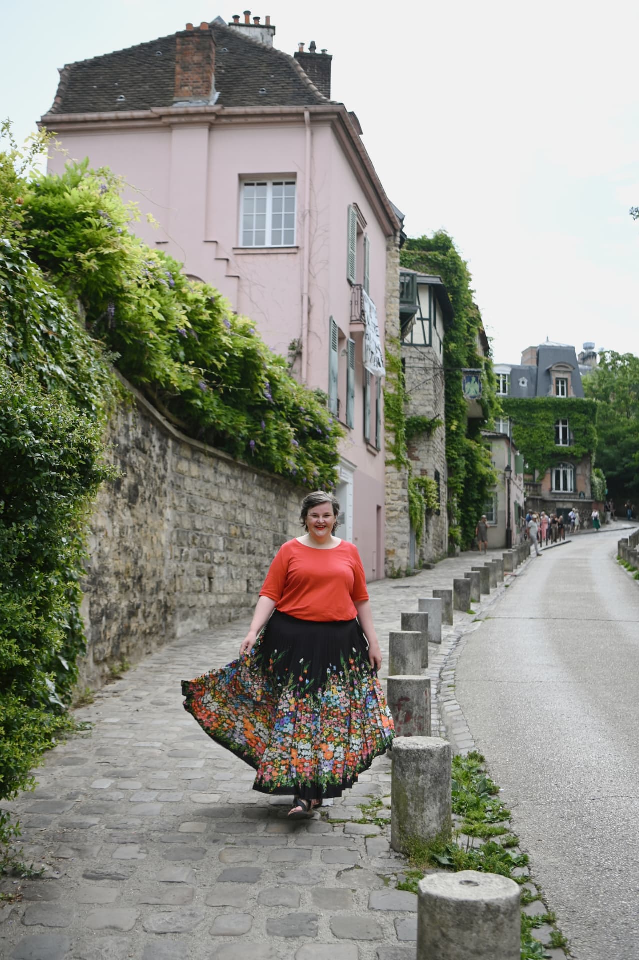 Sanne Frandsen walking a cobbled Paris street in a floral skirt